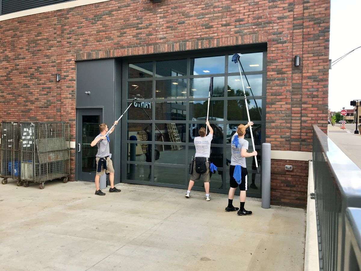 two window cleaners working side by side to clean two windows at an office in New lexington ohio