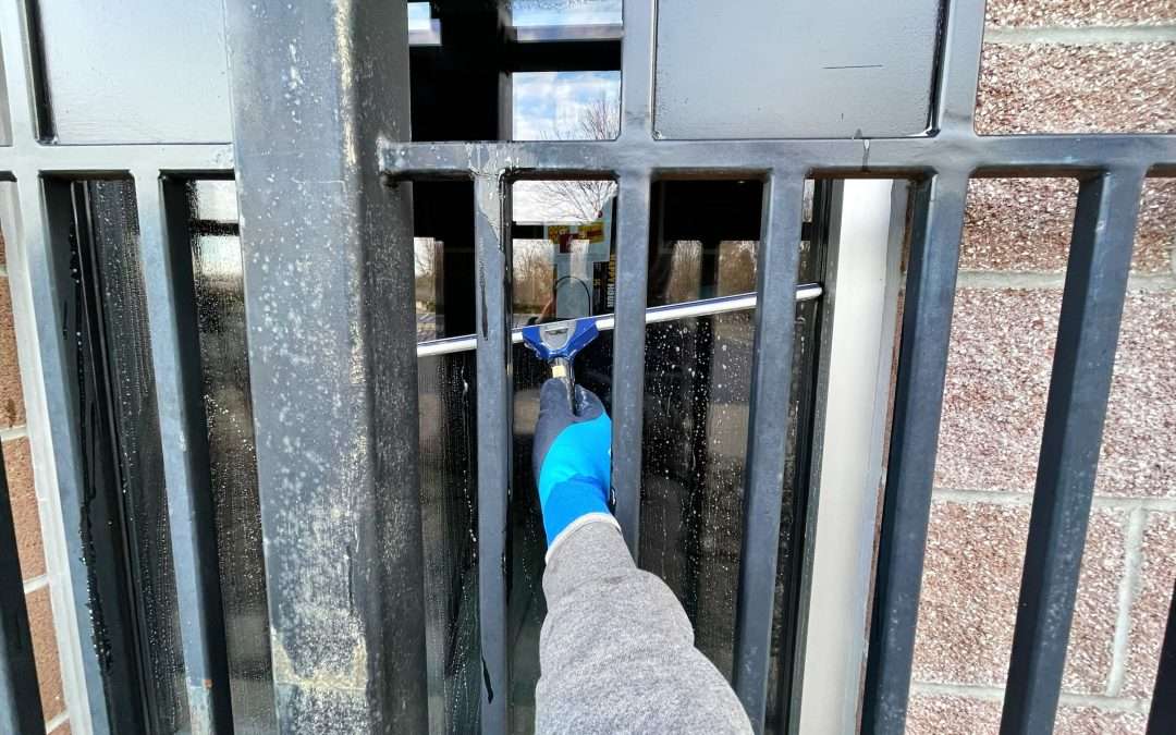 Cleaning glass behind railing
