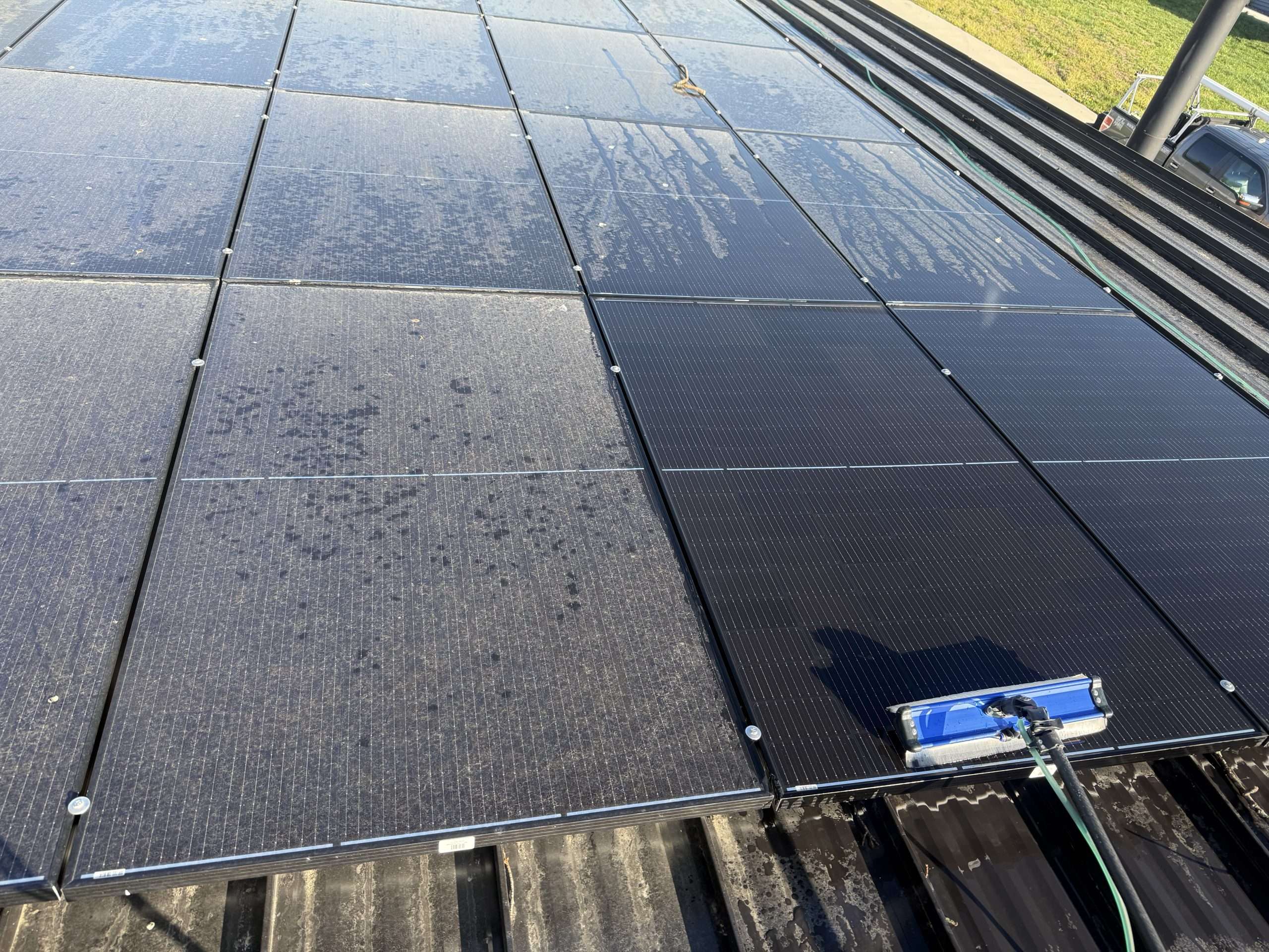 Using pure filtered water and a brush to clean dirt off of solar panels on a roof in Buckeye Lake Ohio