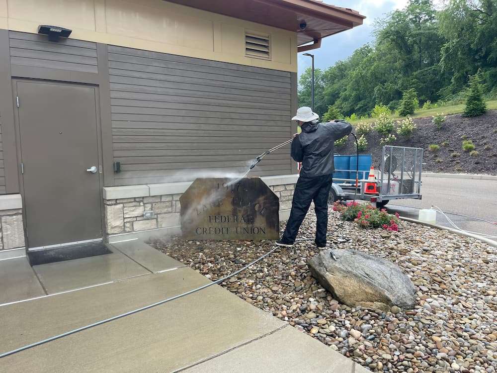 Professional pressure washing by Power Clean cleaning concrete at a bank in Central Ohio