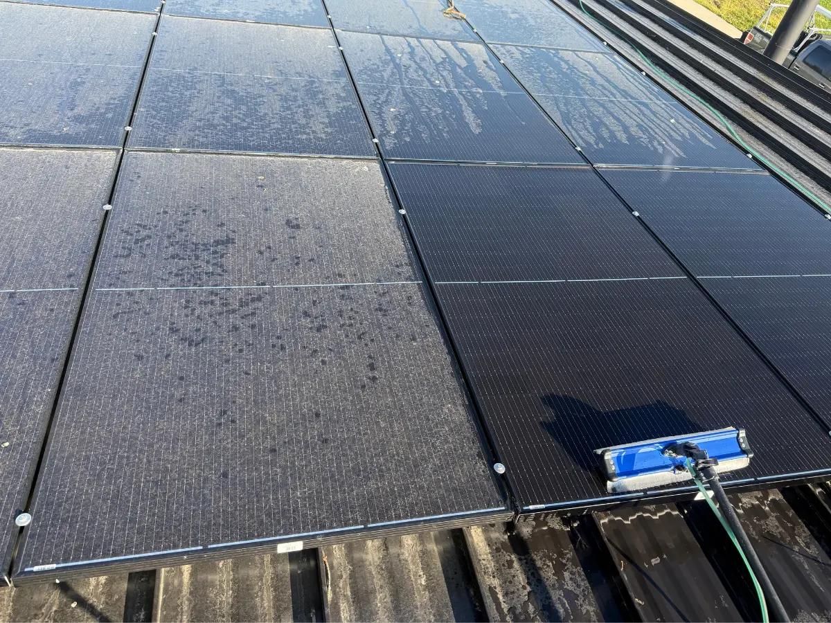 Untitled design (2) Power Clean technician cleaning solar panels with a purified water