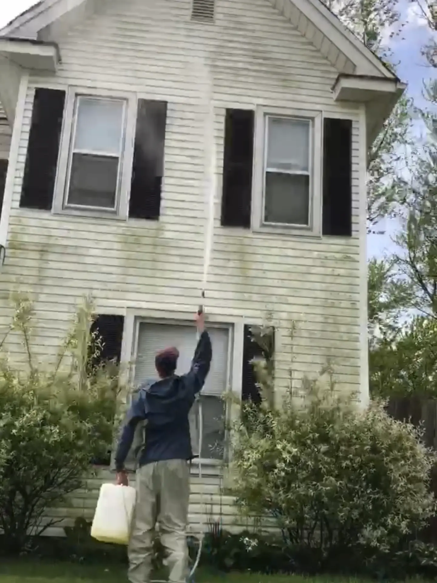 Before-softwashing-house-wash-heath-oh Power Clean technician cleaning high windows on the exterior of a house on Buckeye Lake