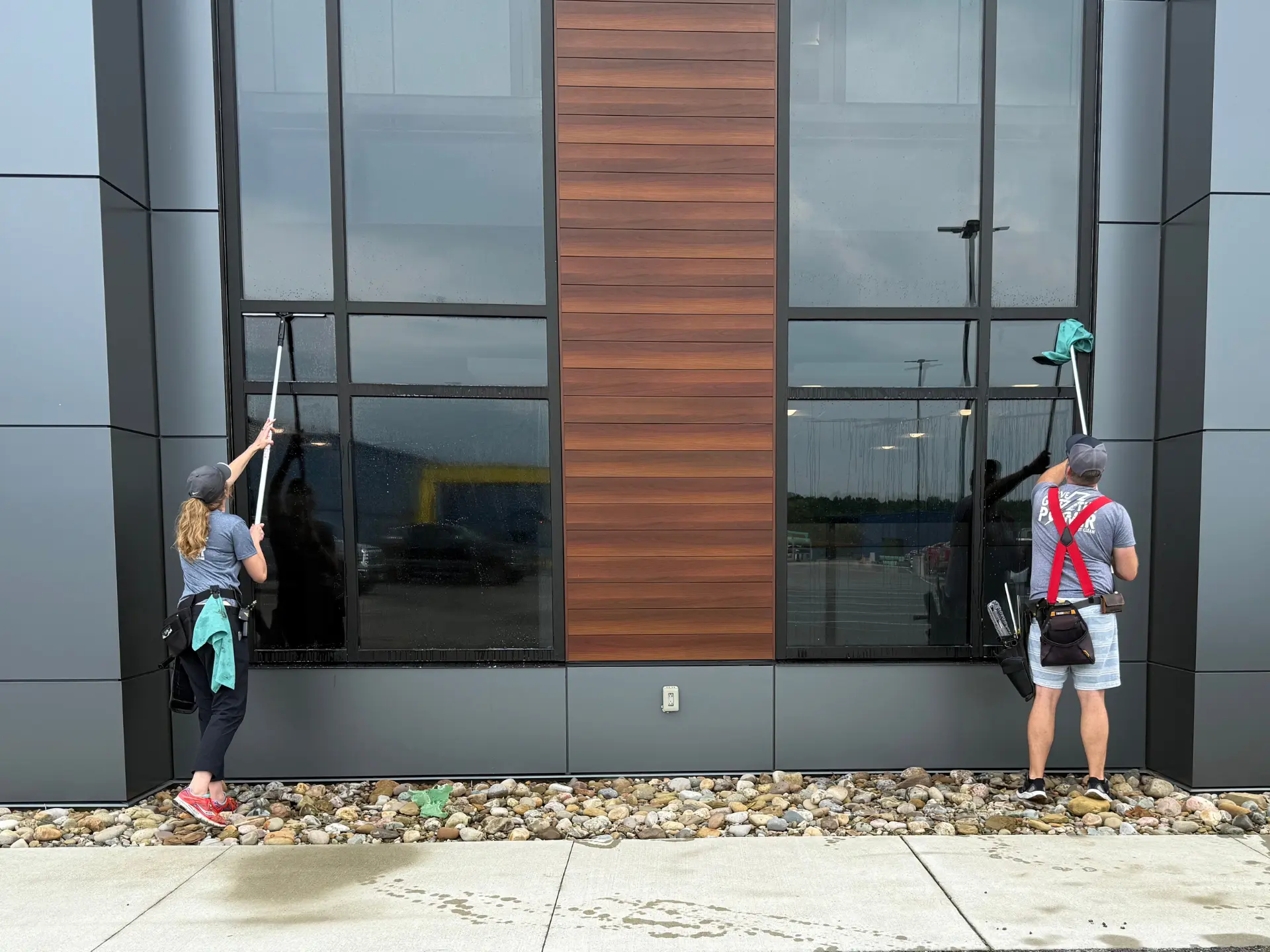 a husband and wife power clean team cleaning the exterior windows with a pole at the Bi-con building in Cambridge oh