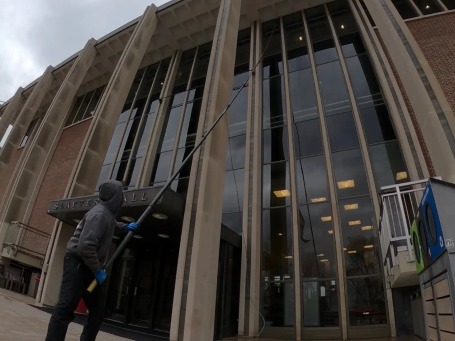 power clean technician using a water fed pole to reach high windows at the Samson Talbit building at Denison university Granville