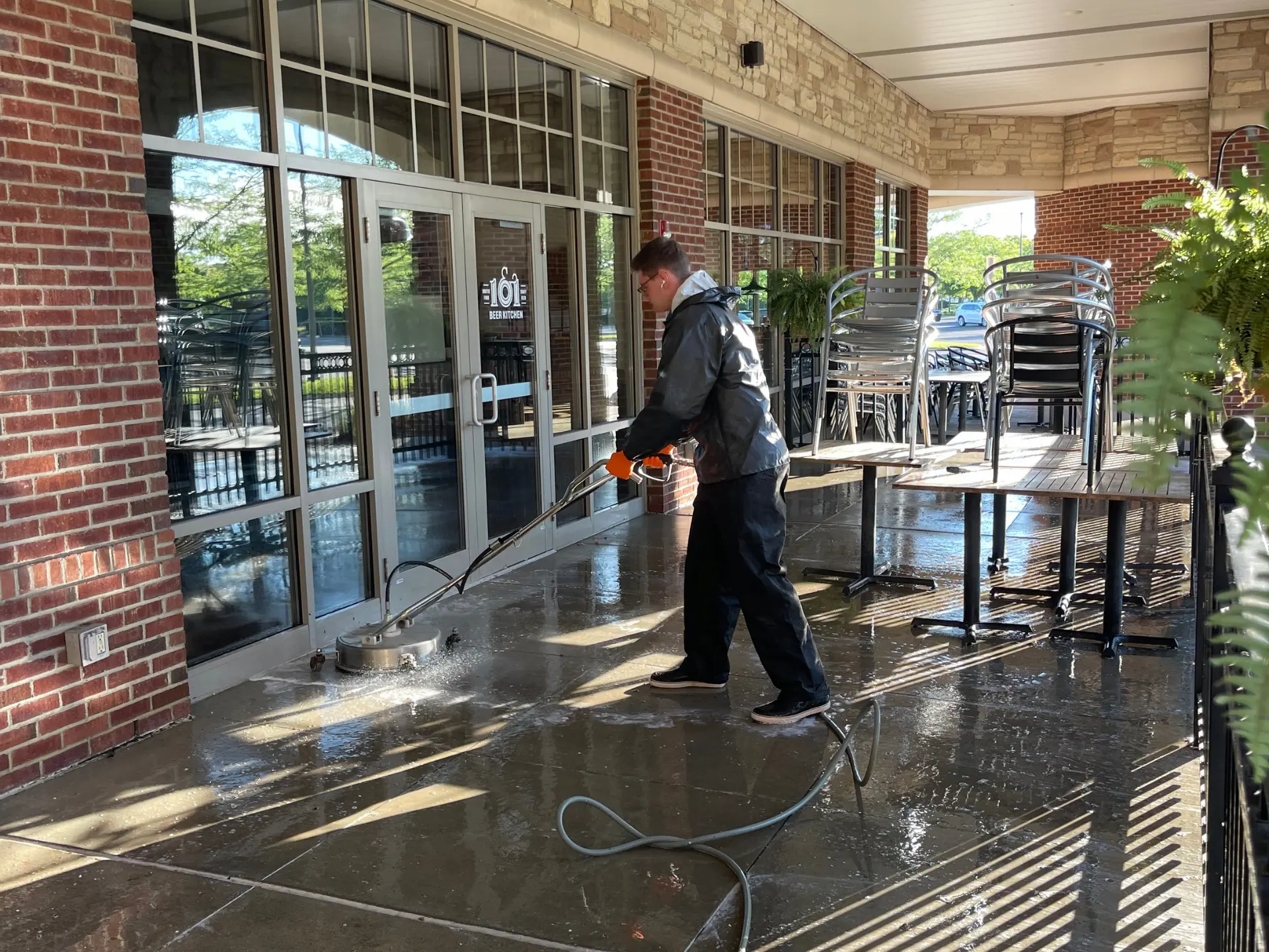 power clean technician pressure washing the entry of 101 beer kichen in columbus