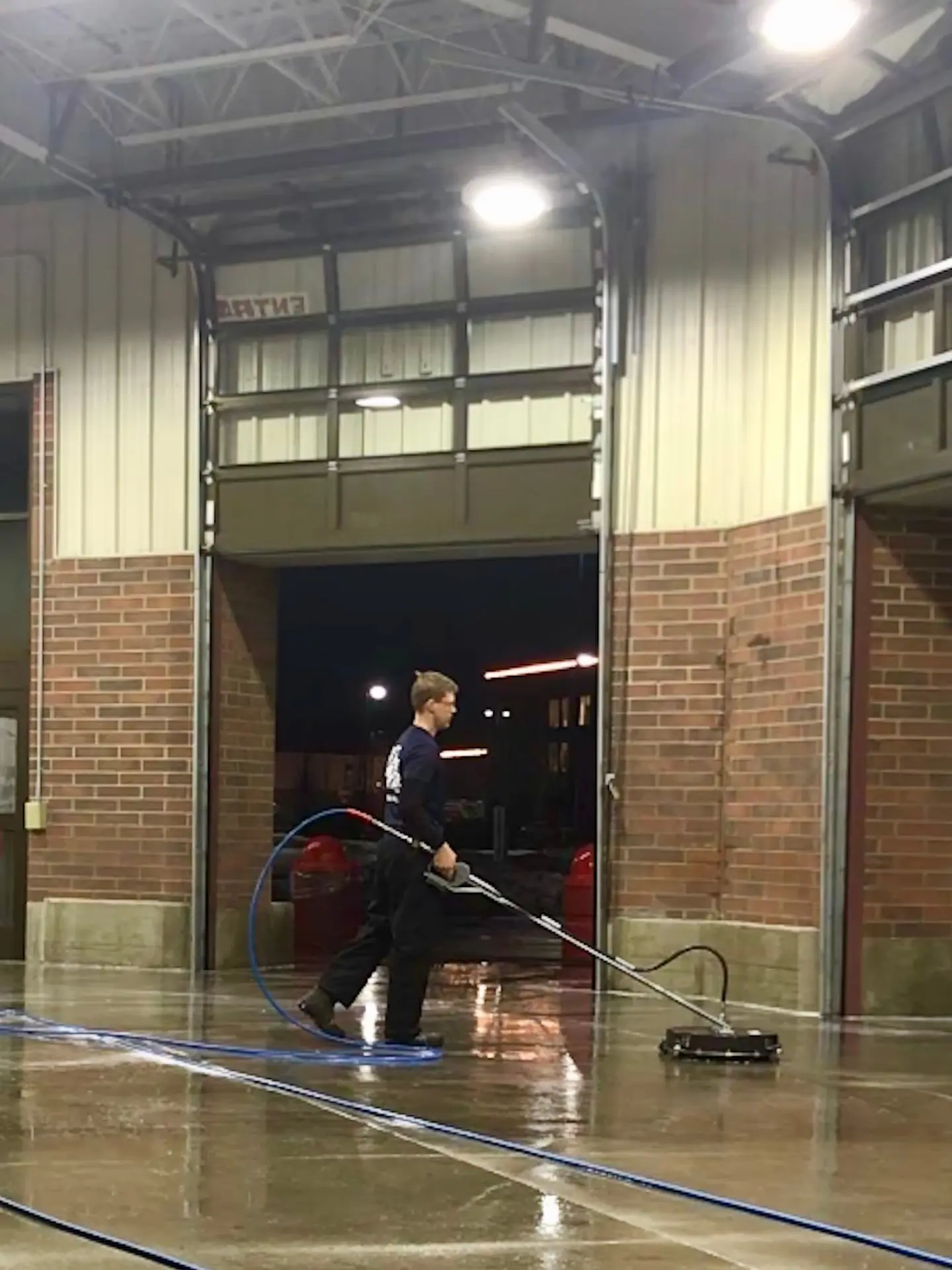 power clean technician pressure washing with a surface cleaner inside the entryway at Costco Easton