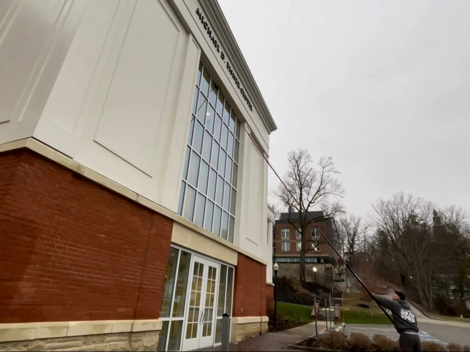 Power clean technician cleaning the exterior windows with a waterfed pole at the michael d eisner building in Denison university Granville