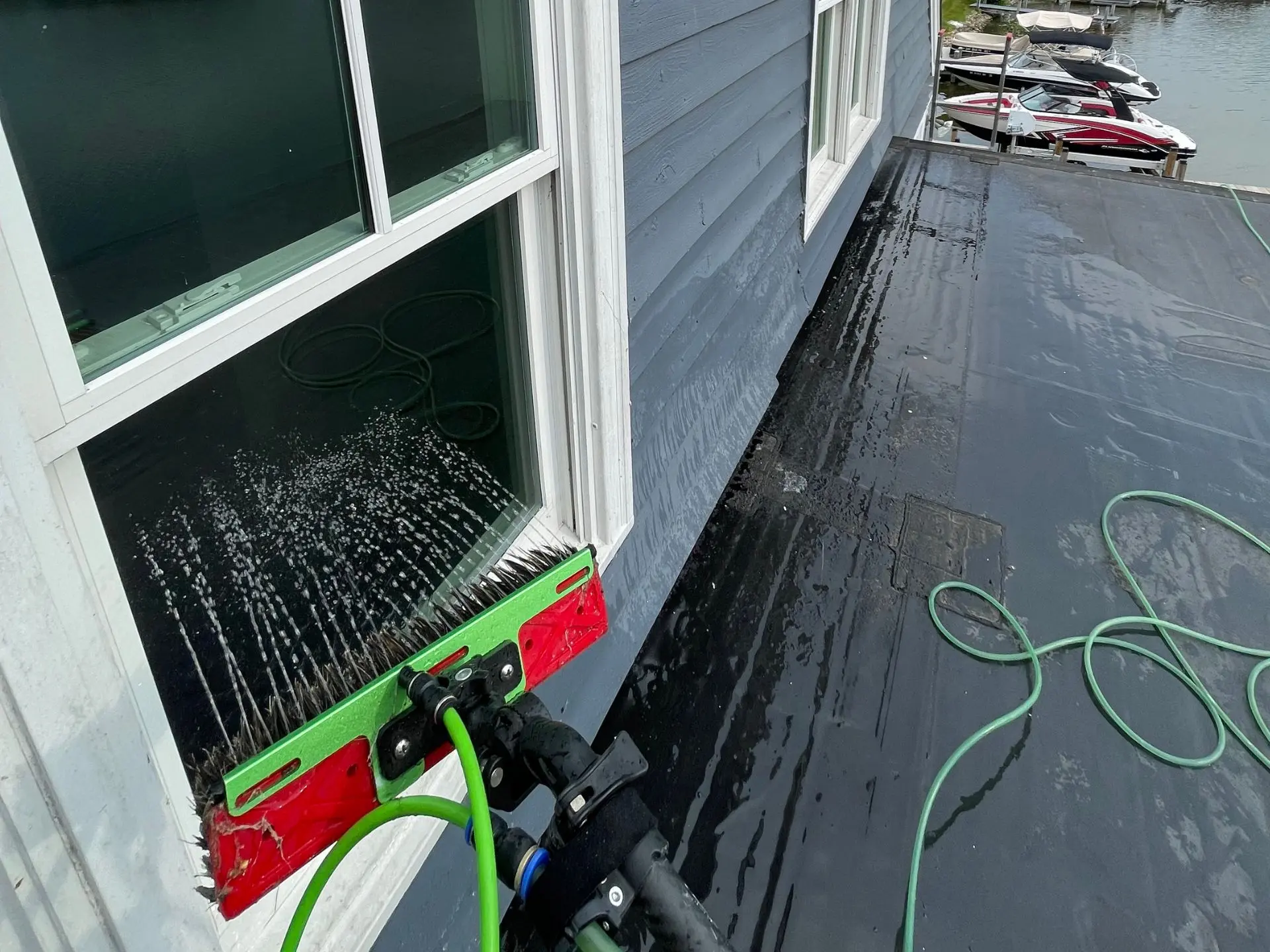 lake-window-cleaning.webp Power clean technician cleaning the third story windows of a home at Buckeye Lake OH