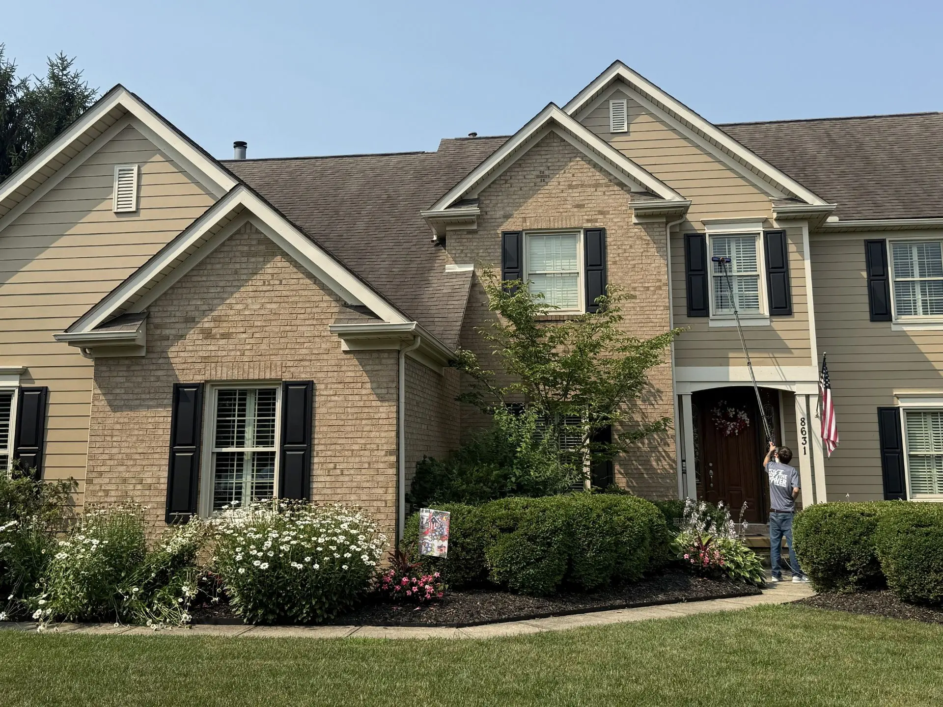outside-window-cleaning.webp Power clean technician using a pole to clean the second story windows of a house in central oh