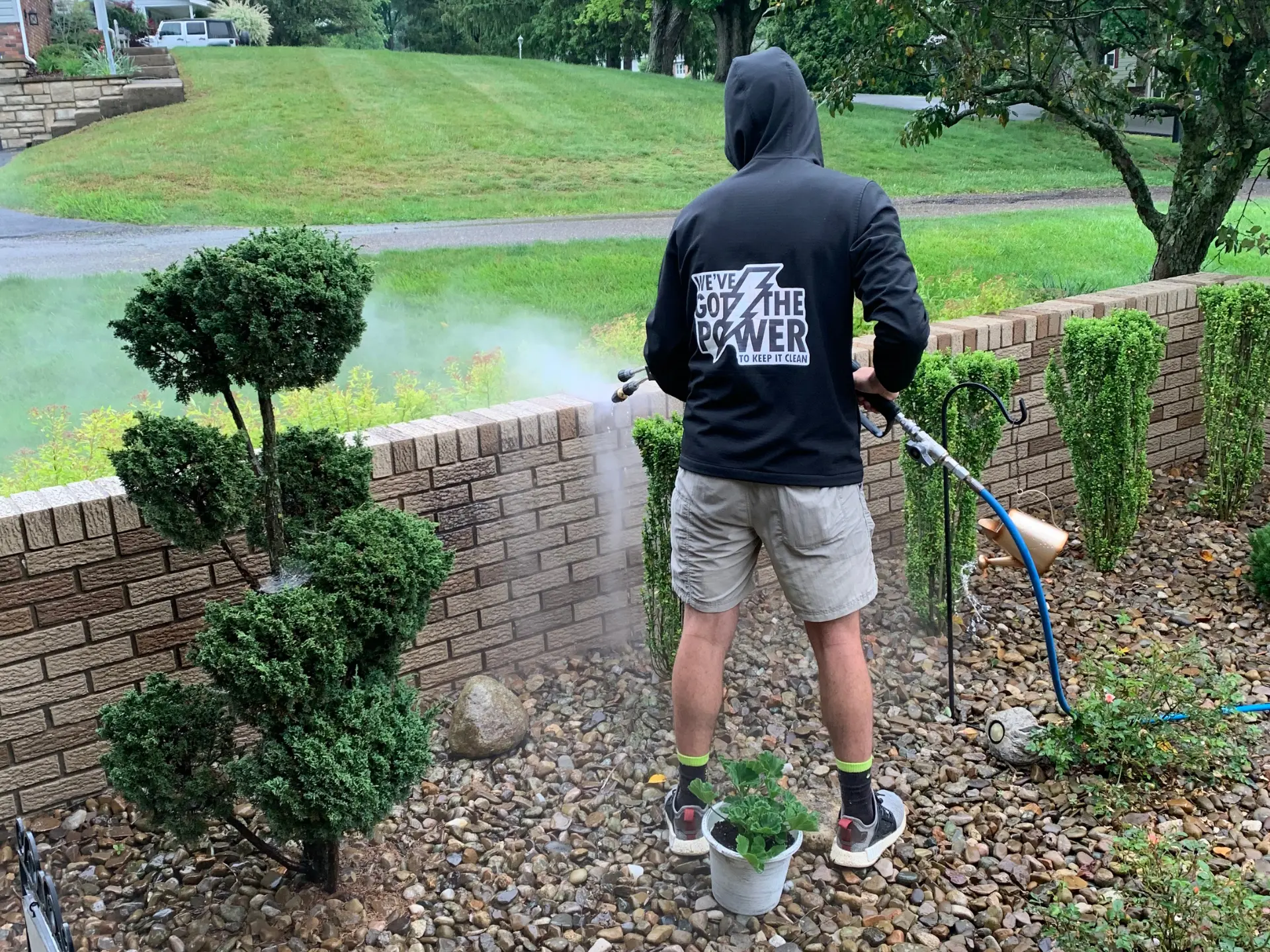 Power Clean technician pressure washing a brick fenceline in Zanesville OH