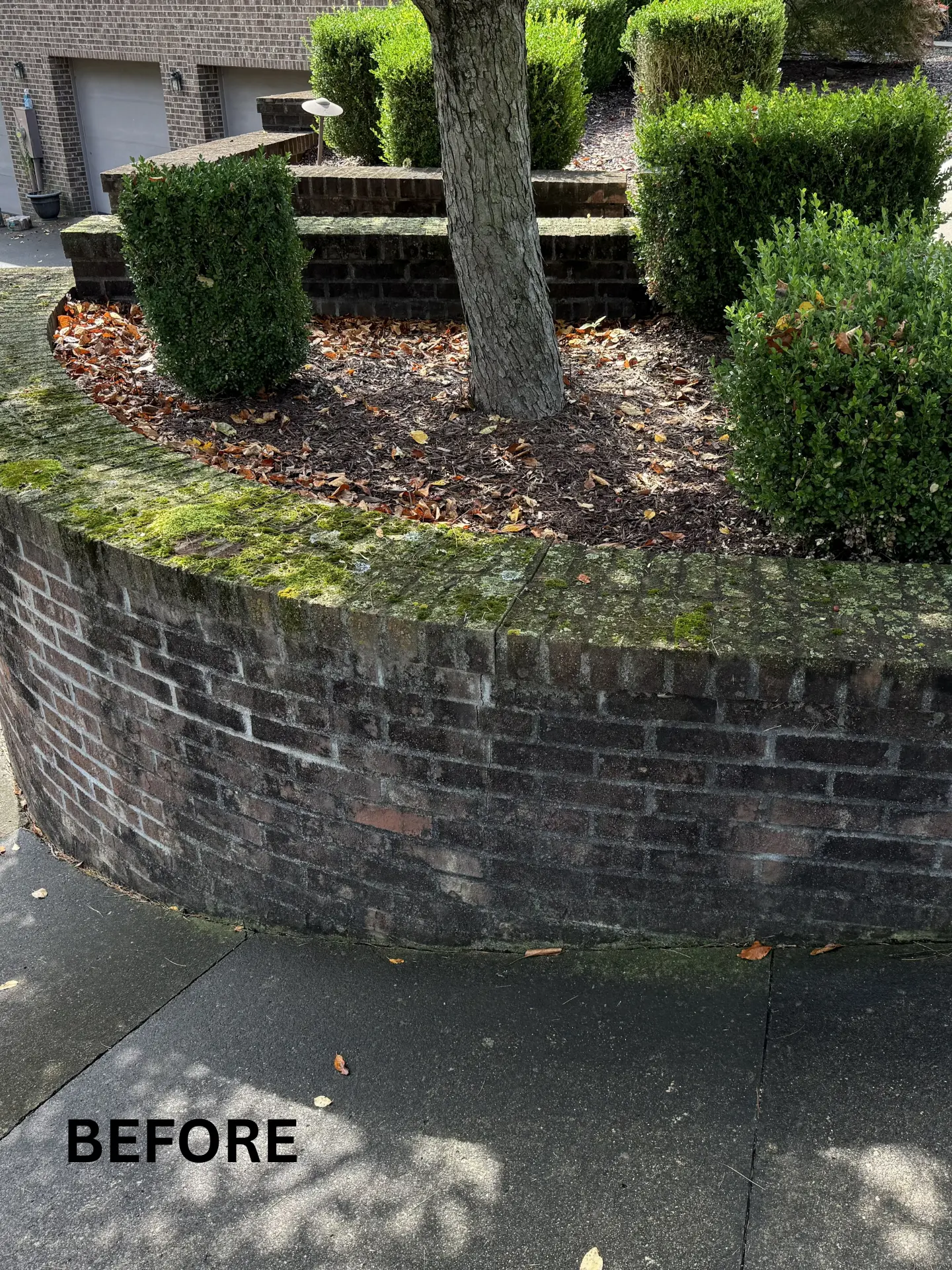 brick retaining wall before being pressure washed by power clean