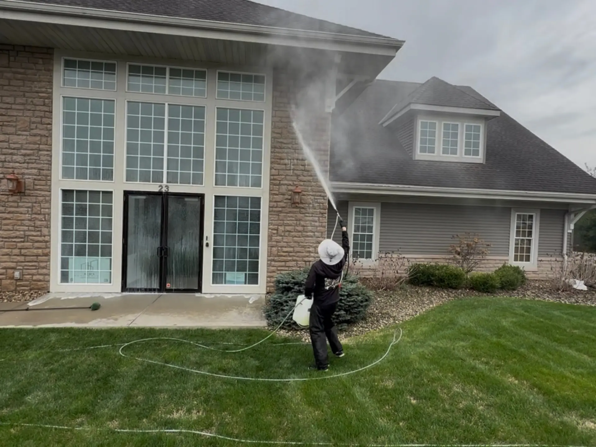 Power clean technician soft washing a commercial office building in Newark, OH