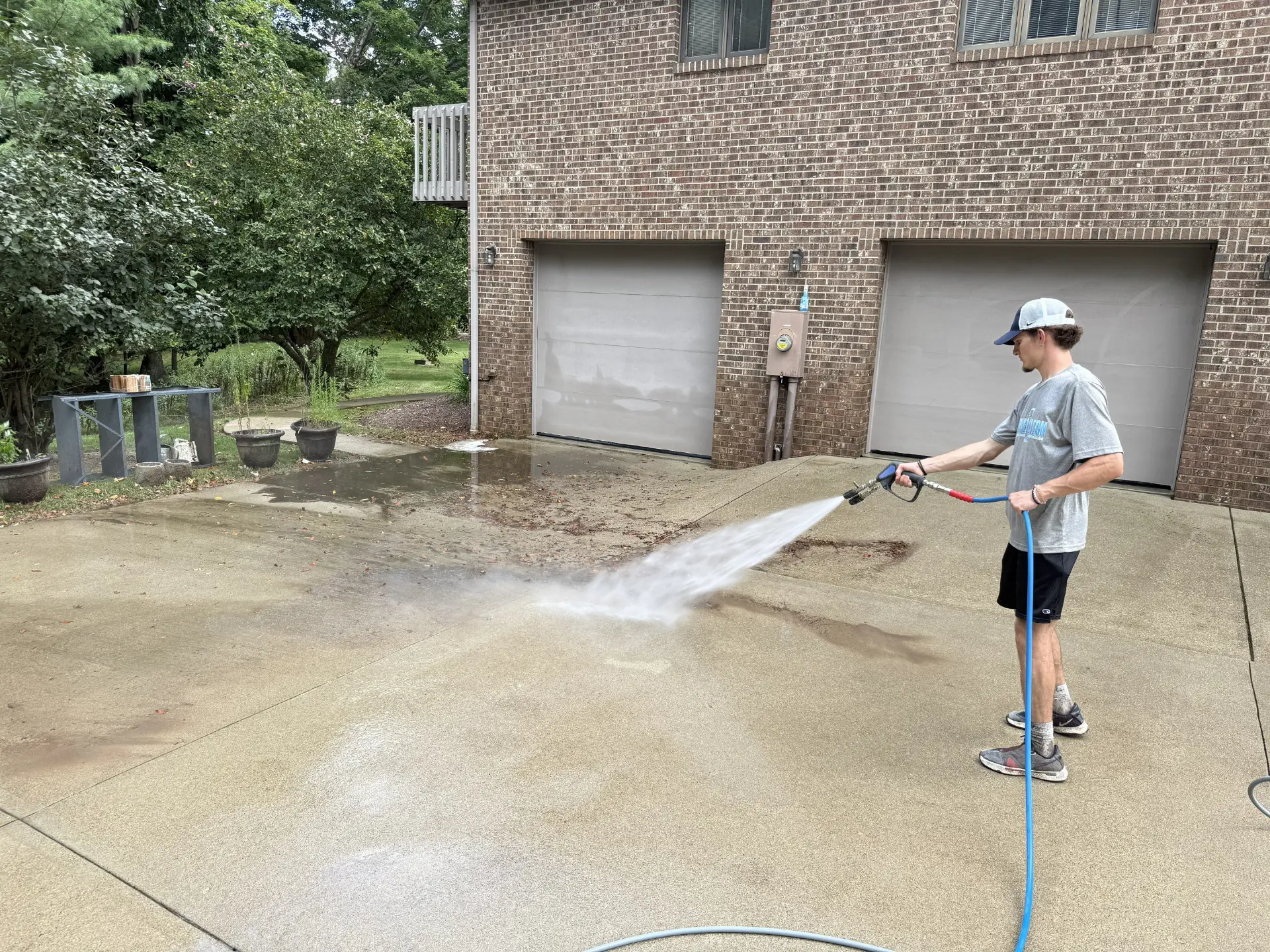 Power Clean technician pressure washing the concrete pad of a home in Lancaster OH