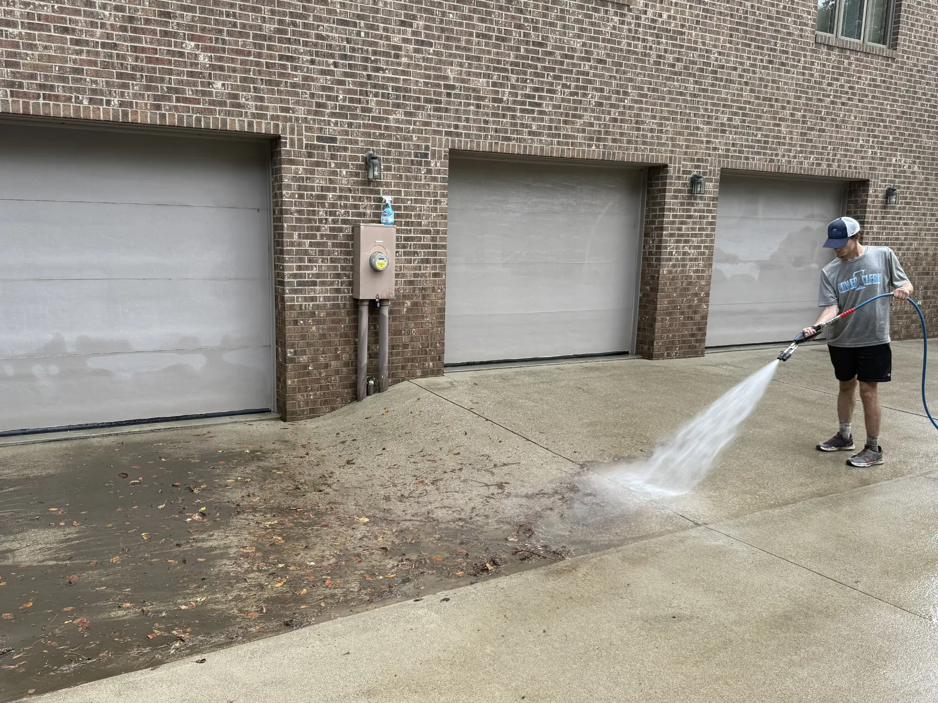 Power Clean technician pressure washing the concrete pad of a home in Lancaster OH