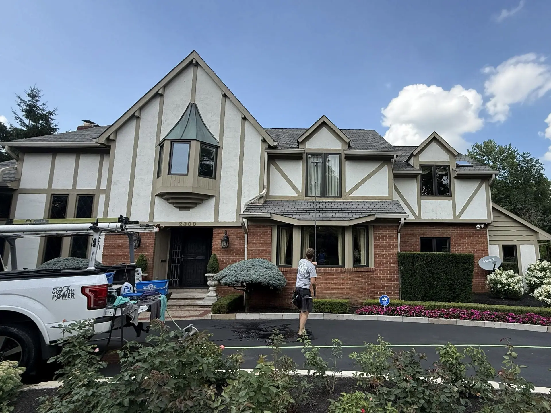 residential-house-window-cleaning.webp power clean technician cleaning the second story windows of a home