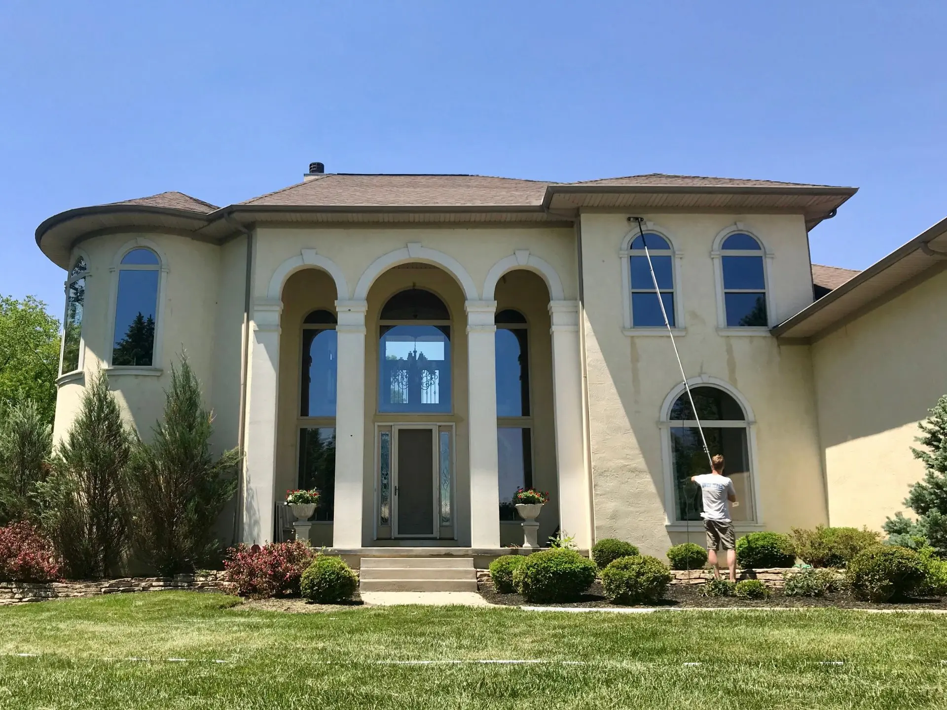 residential-window-cleaning.webp Power clean technician cleaning the second story windows of a home in central oh