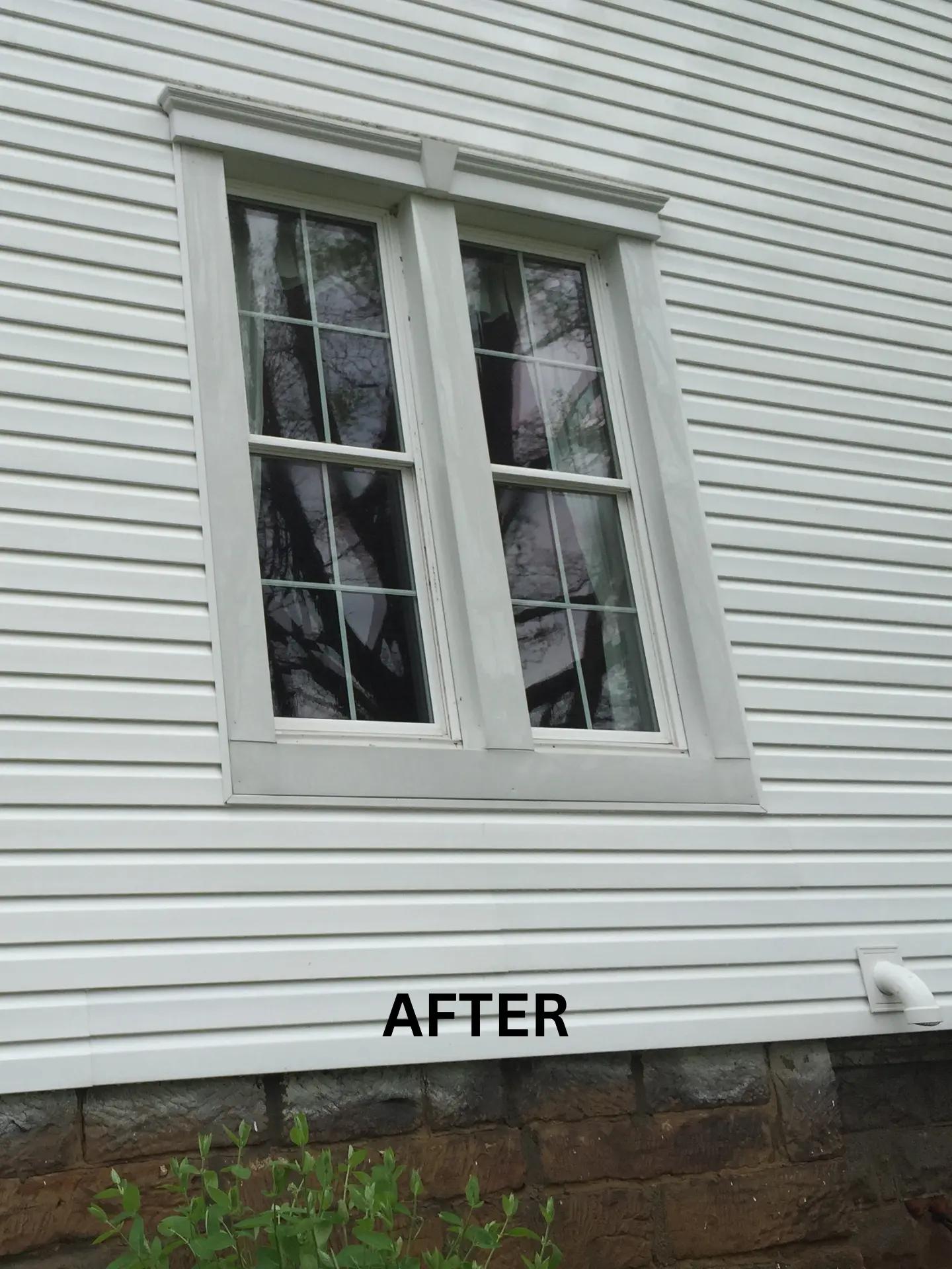 side-house-washing-after close up of white house free of green algae growing after being pressure washed