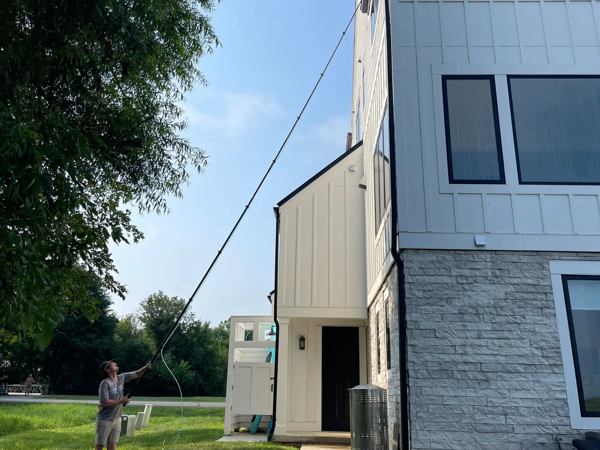 third-story-window-cleaning.webp Power clean technician cleaning the third story windows of a home in Heron Bay Thornville, oh
