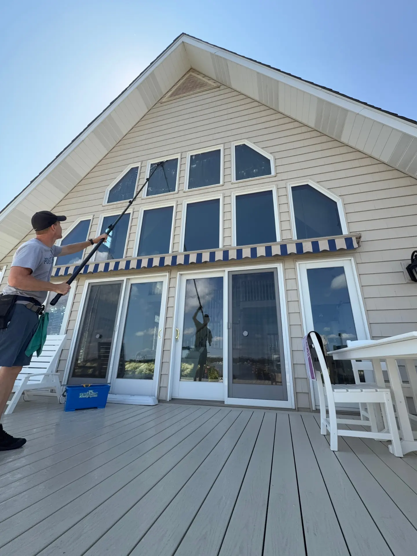 Power Clean technician cleaning high windows on the exterior of a house on Buckeye Lake